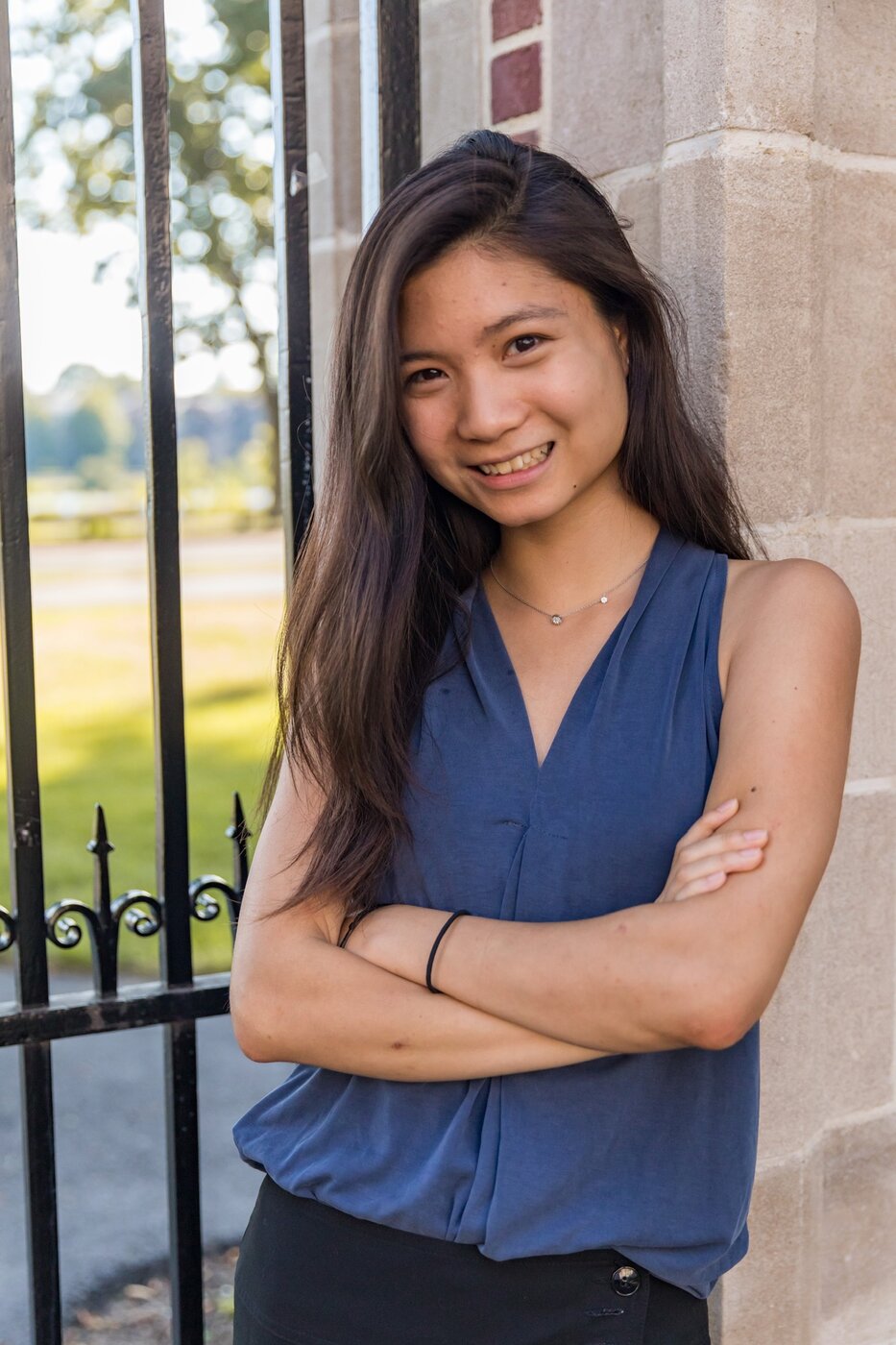 Karis as a Harvard undergraduate, leaning against a stone gate